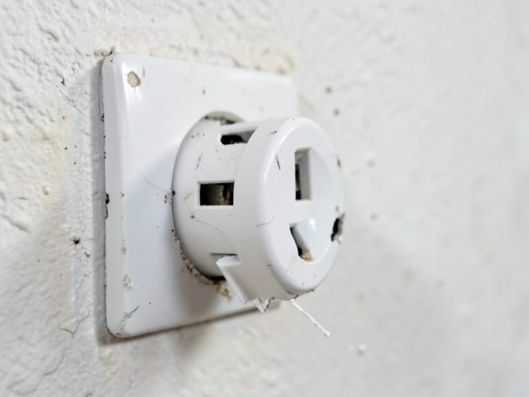 Uszkodzone, obluzowane gniazdko elektryczne w ścianie